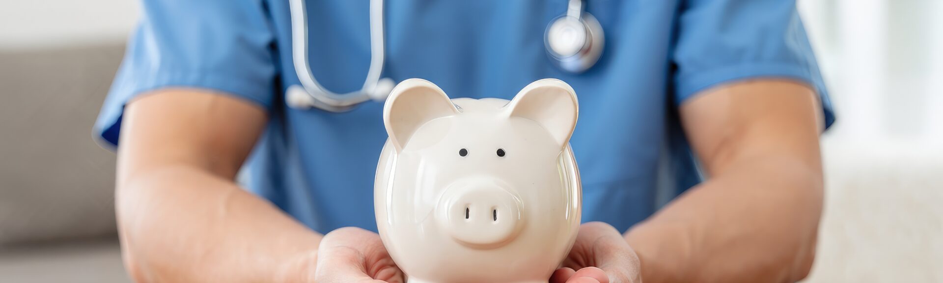 Nurse or doctor with stethoscope holding piggy bank in hand. Concept of medical expenses, finance, saving money, health insurance, medicine, donation and pension. Healthcare service cost.